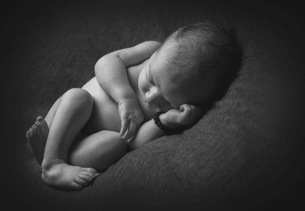 Newborn baby boy, as captured by Lisa from Adelaide Newborn Photography in Black and white
